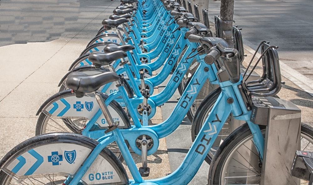 a row of blue bicycles parked next to each other