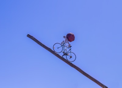 Character balancing on a unicycle on a narrow beam with a bright background.
