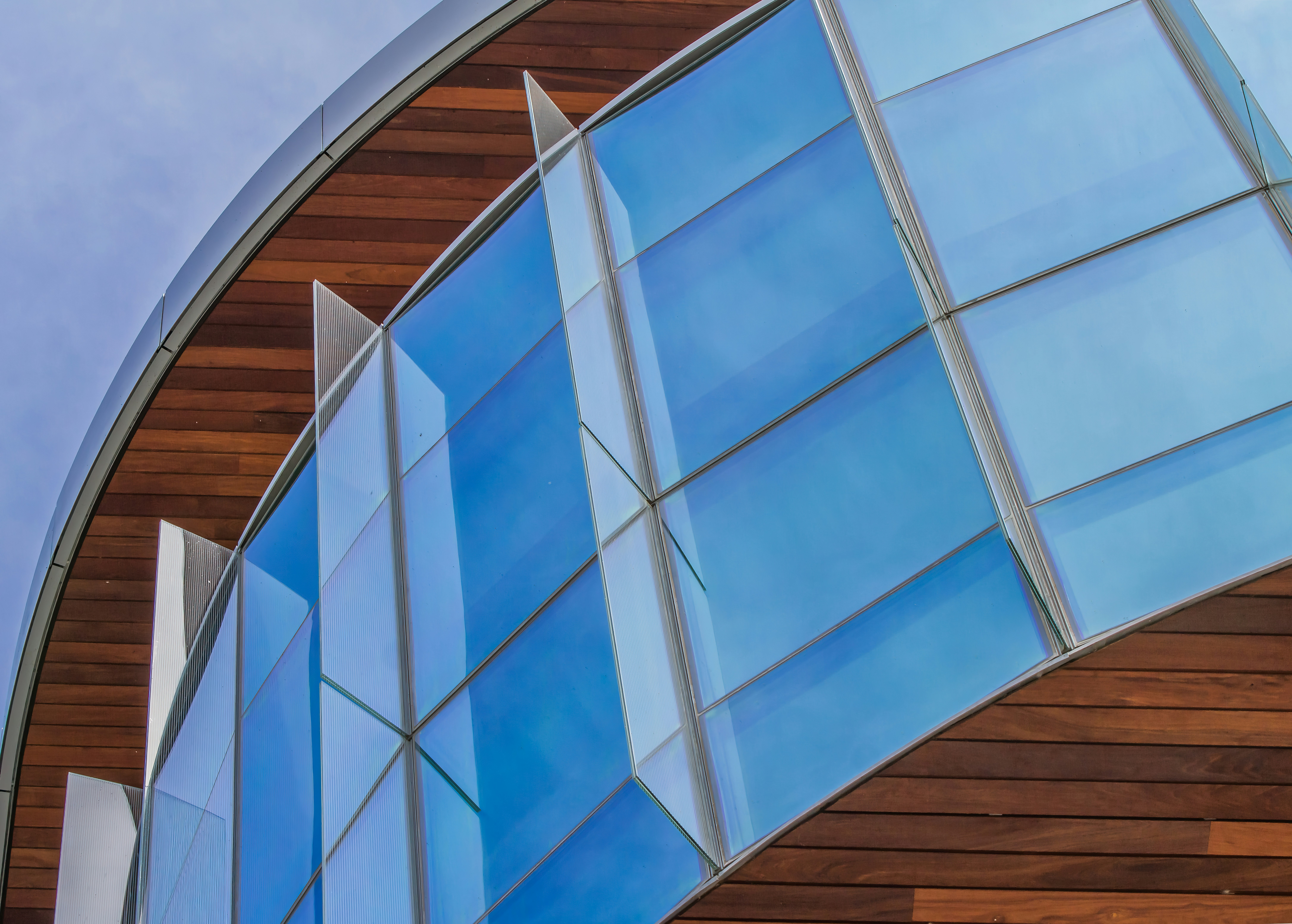a close up of a curved building with a sky background