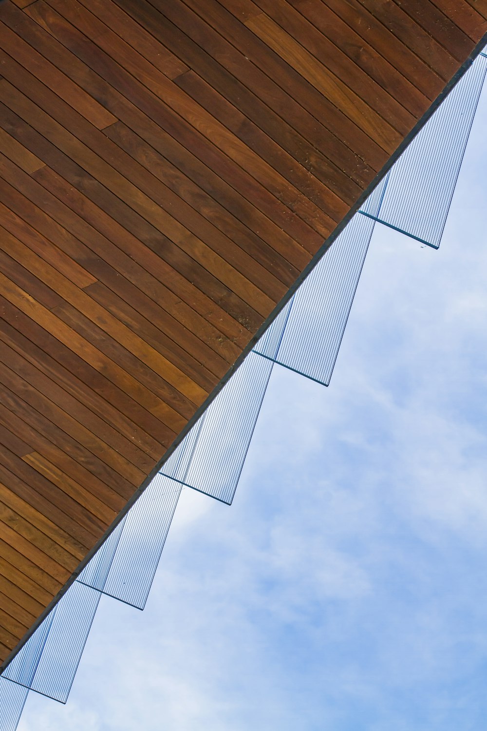 a building with a wooden roof and a blue sky in the background