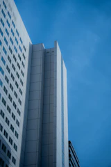 High-rise building exterior emphasizing sleek architectural and structural design under a clear sky.