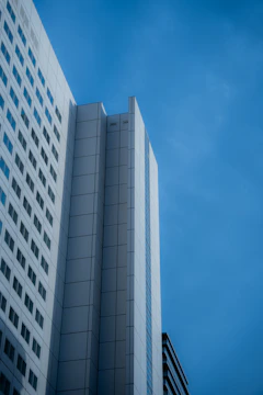 High-rise building exterior emphasizing sleek architectural and structural design under a clear sky.