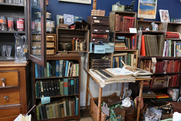 Organized shelves showcasing books, glassware, and small antiques at a recent estate sale.