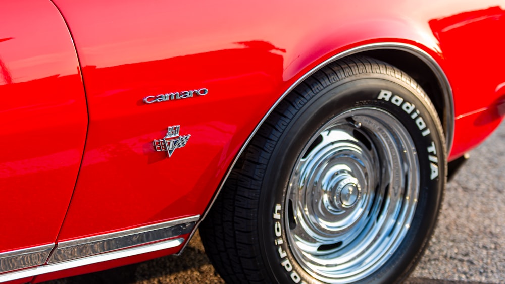 a close up of a red car with chrome rims