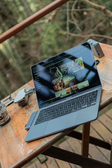 Maurice sitting outdoors with a laptop, surrounded by nature and drone gear.