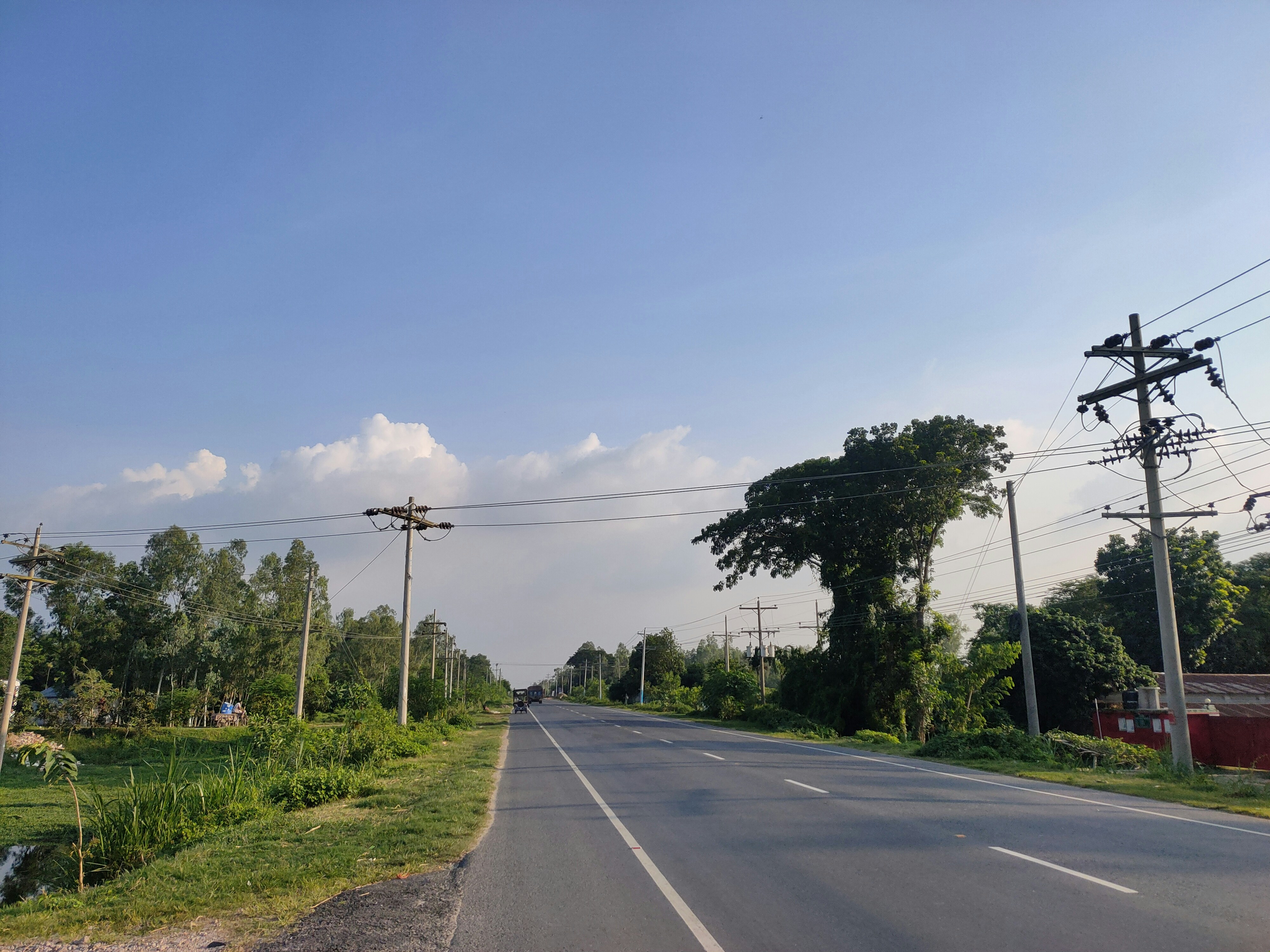 an empty street with power lines and telephone poles