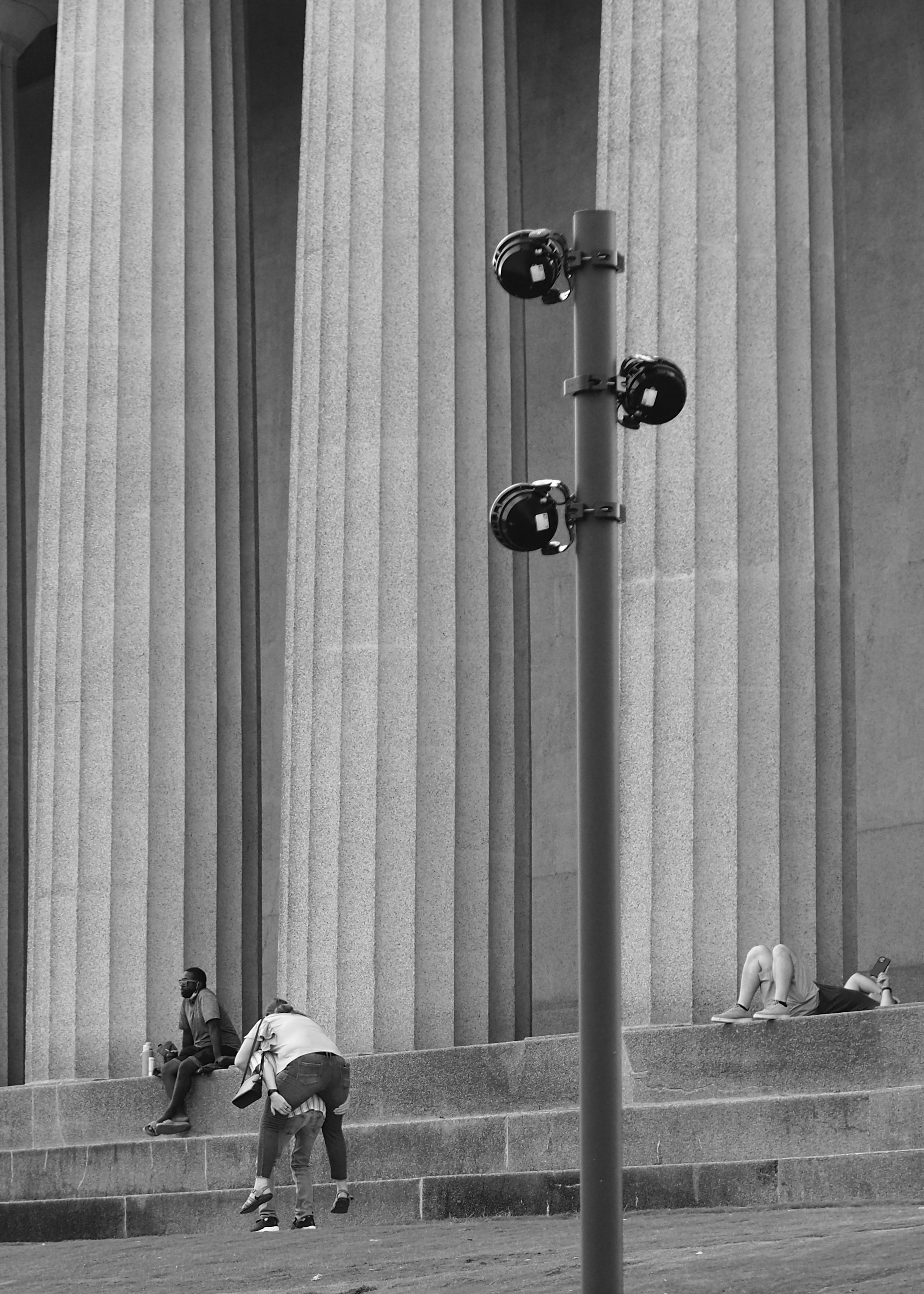 eine person, die auf einer bank vor einem gebäude sitzt