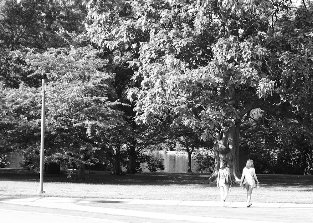 a couple of people walking down a street holding hands