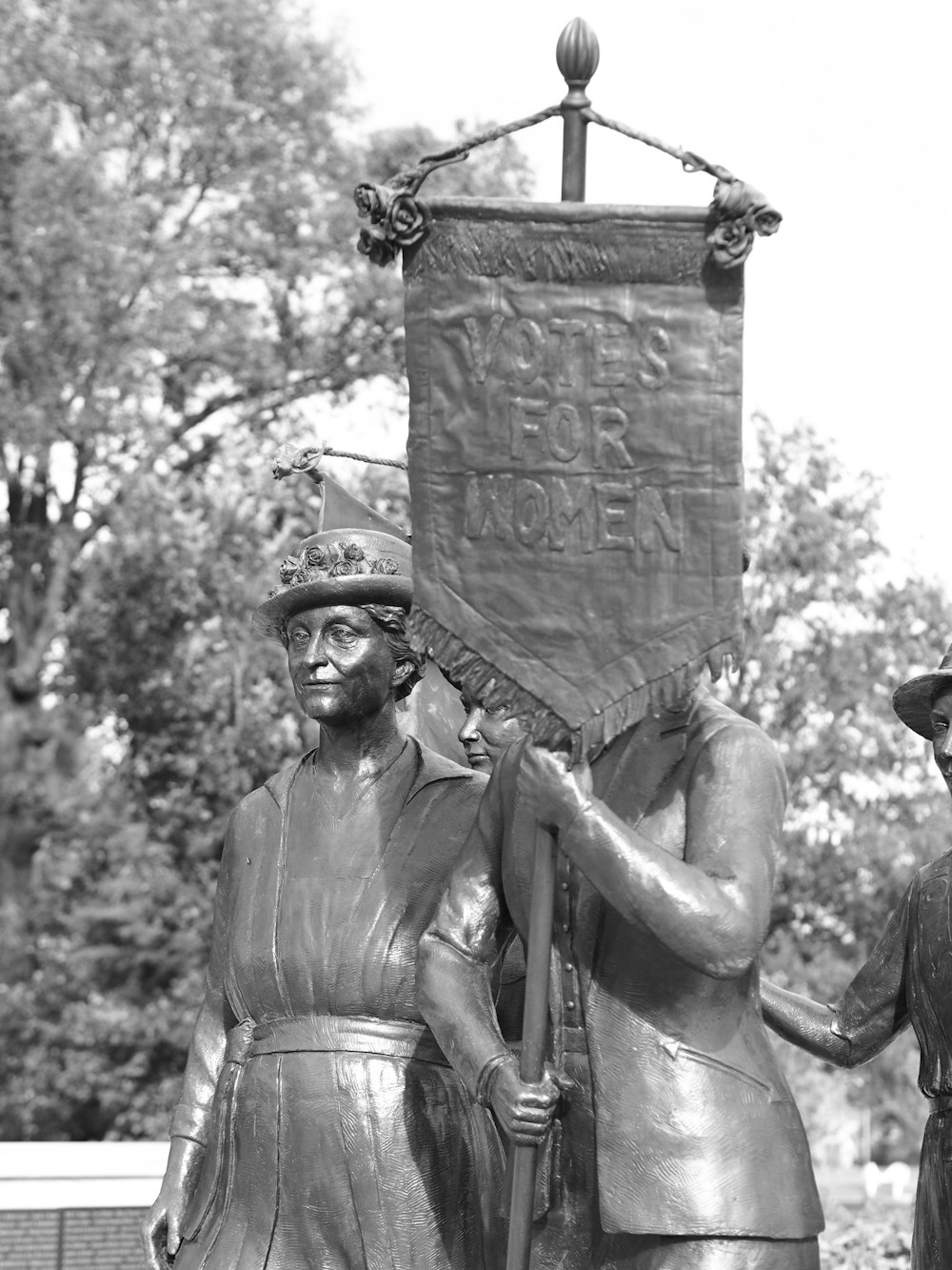a statue of two men holding a banner