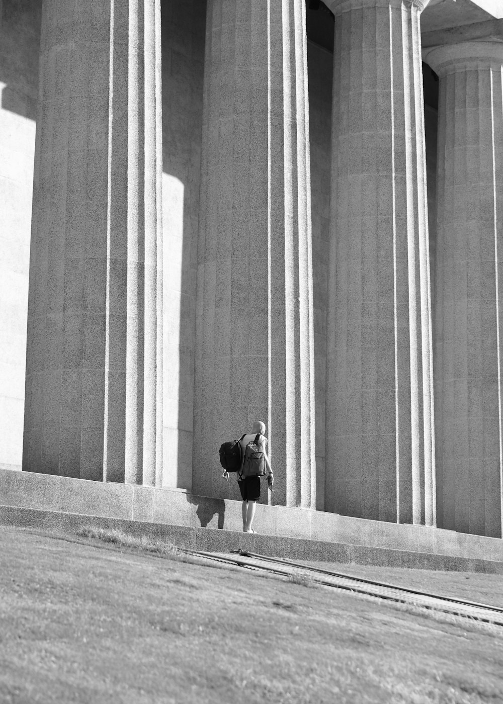 a person is standing in front of some pillars