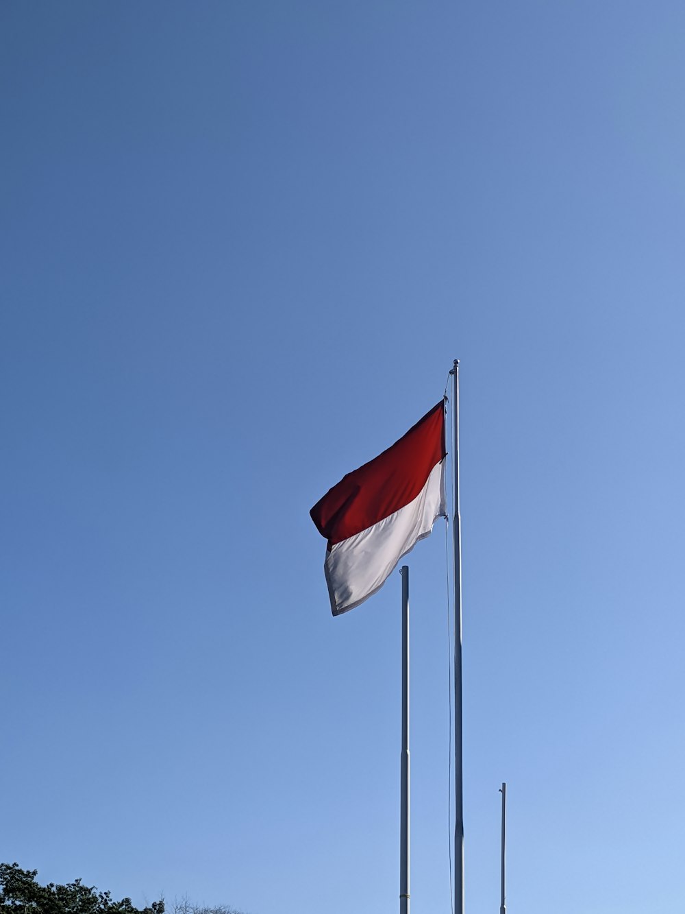 a red and white flag flying in the sky