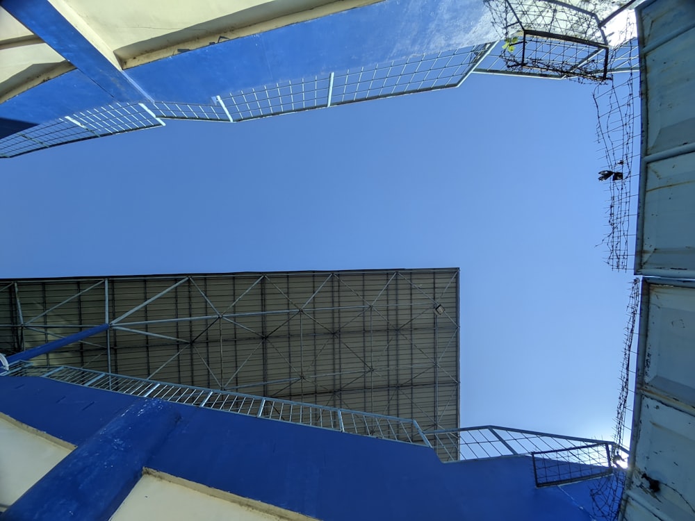 looking up at a metal structure with a sky background