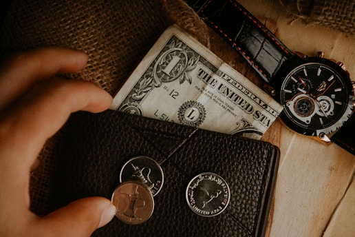A close-up of a wallet with cash and coins, representing financial management and savings.