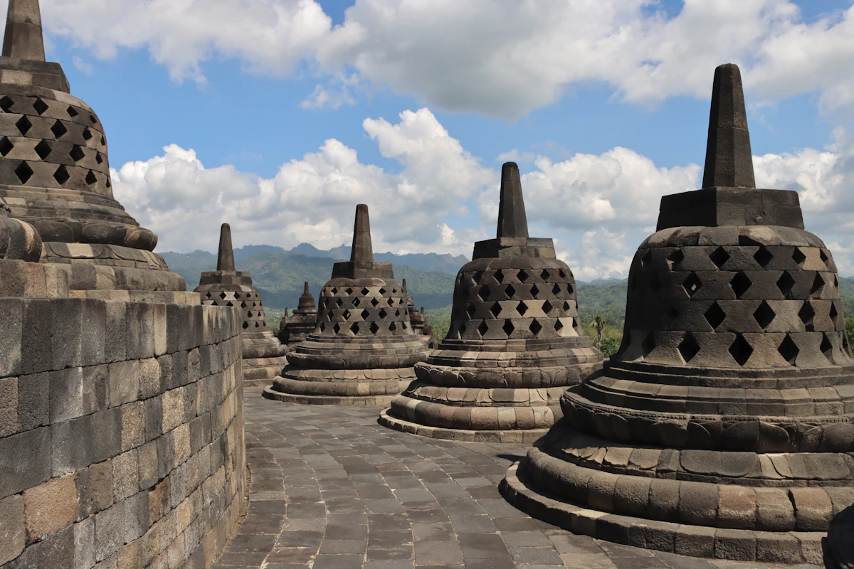 Stone bell-shaped stupas of Borobudur overlooking the tranquil Kedu Plain at dawn