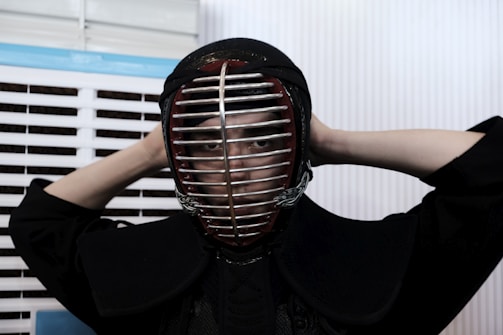 Close-up of a kendoka's focused eyes behind the men helmet during training.