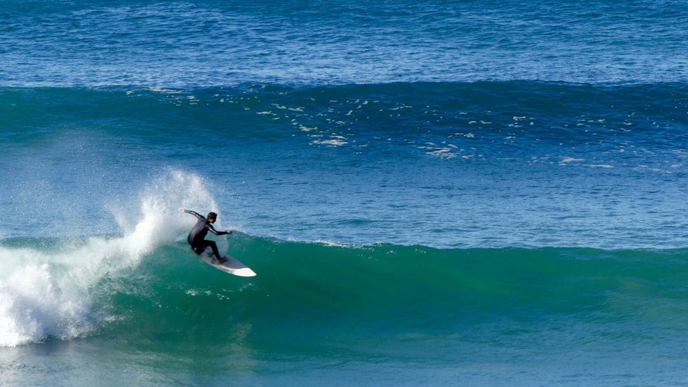 a man riding a wave on top of a surfboard