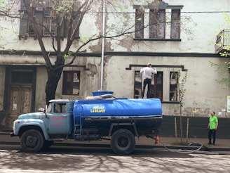 a blue truck parked on the side of a road
