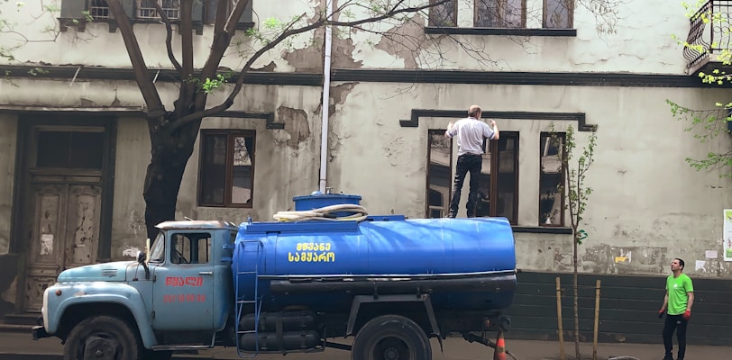 a blue truck parked on the side of a road