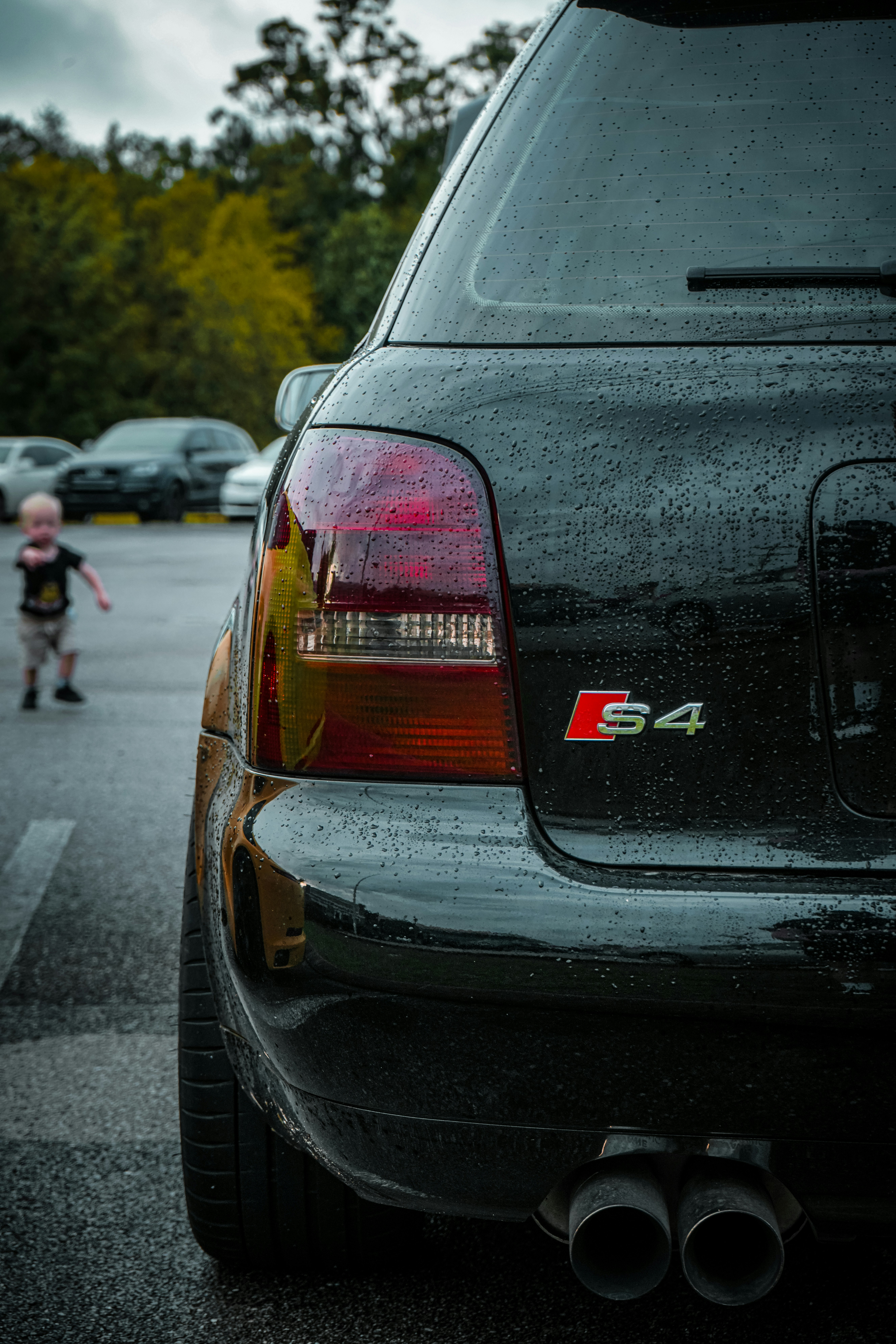 a car parked in a parking lot next to a child
