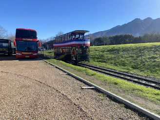 A sleek, modern tourist bus parked in a scenic mountain area at sunrise.