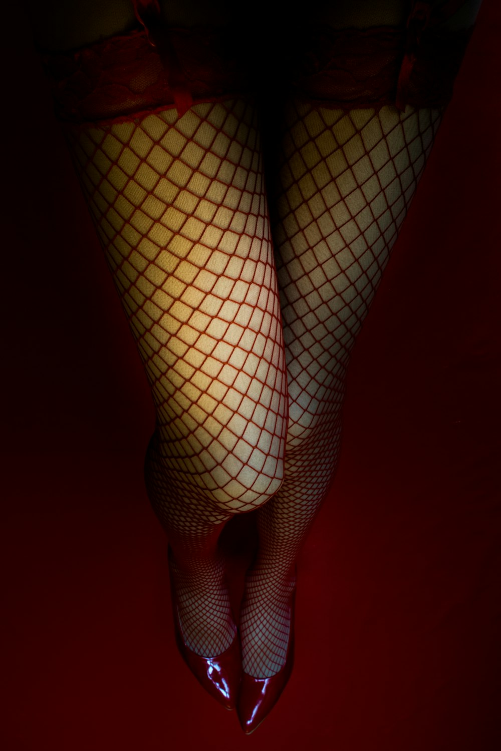 a woman's legs with fishnet stockings and heels