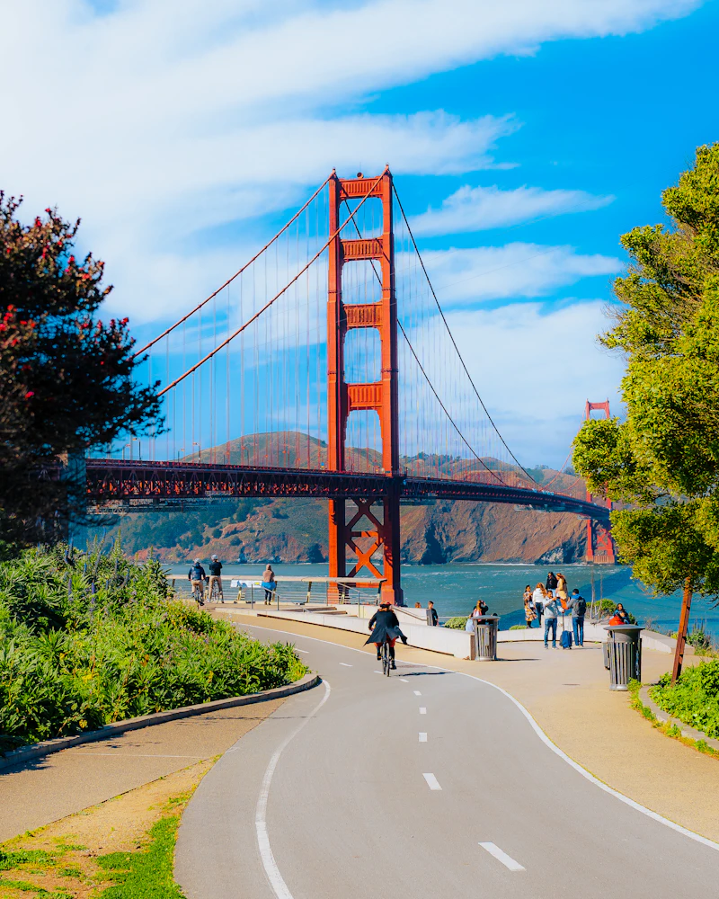 San Francisco trade expo venue - a person riding a bike on a road near a bridge