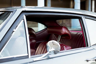 Side view of a vintage Beetle with restored interior visible through open doors.