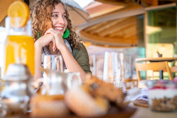 Smiling guest enjoying breakfast in the hotel dining area.