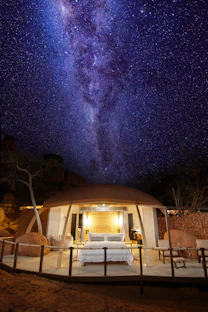 a bed sitting under a night sky filled with stars