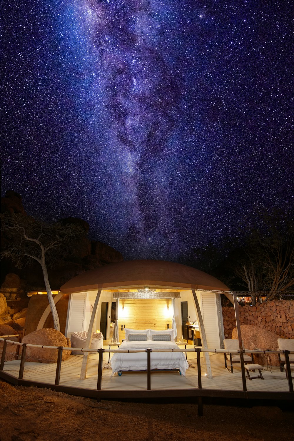 a bed sitting under a night sky filled with stars