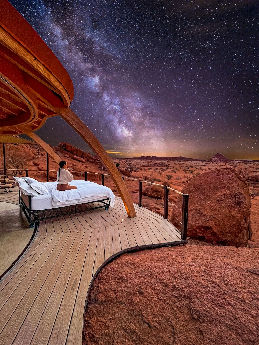 a person sitting on a chaise lounge in the desert