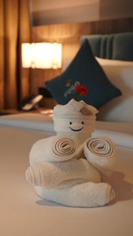 Smiling cleaning staff arranging fresh towels in a hotel room.