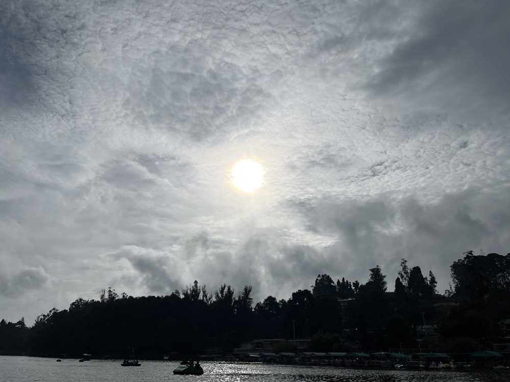 the sun is shining through the clouds over the water