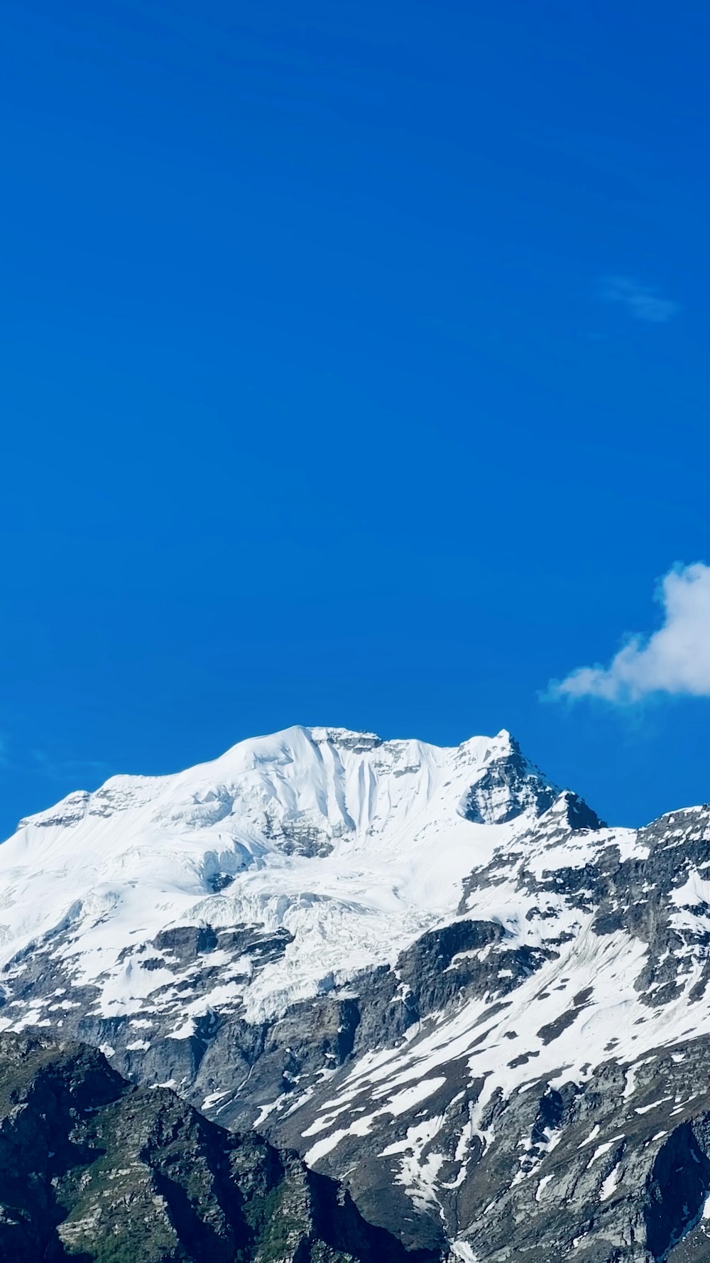 Ein schneebedeckter Berg unter blauem Himmel