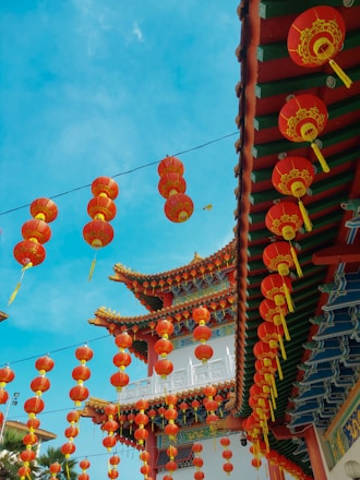 a group of red and yellow lanterns hanging from a roof