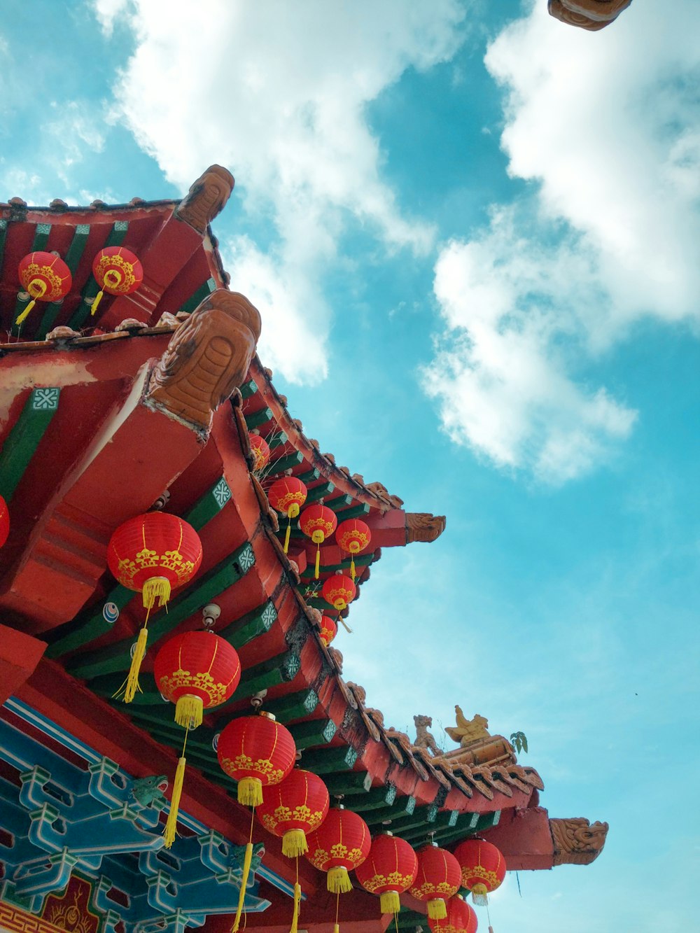 a building with red and yellow lanterns hanging from it's roof