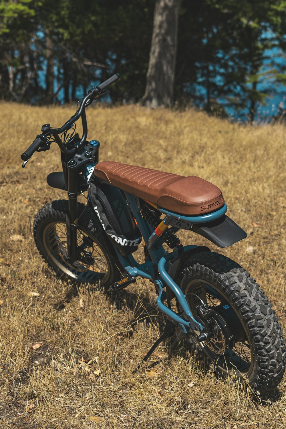 a dirt bike parked in a field with trees in the background