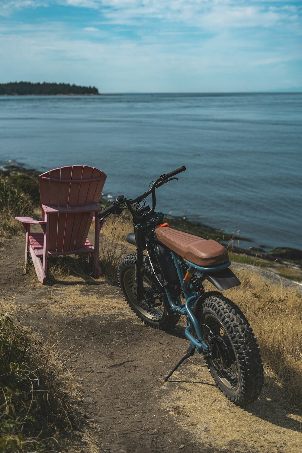 uma bicicleta de terra estacionada ao lado de uma cadeira rosa