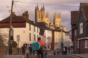 a man riding a bike down a street next to tall buildings