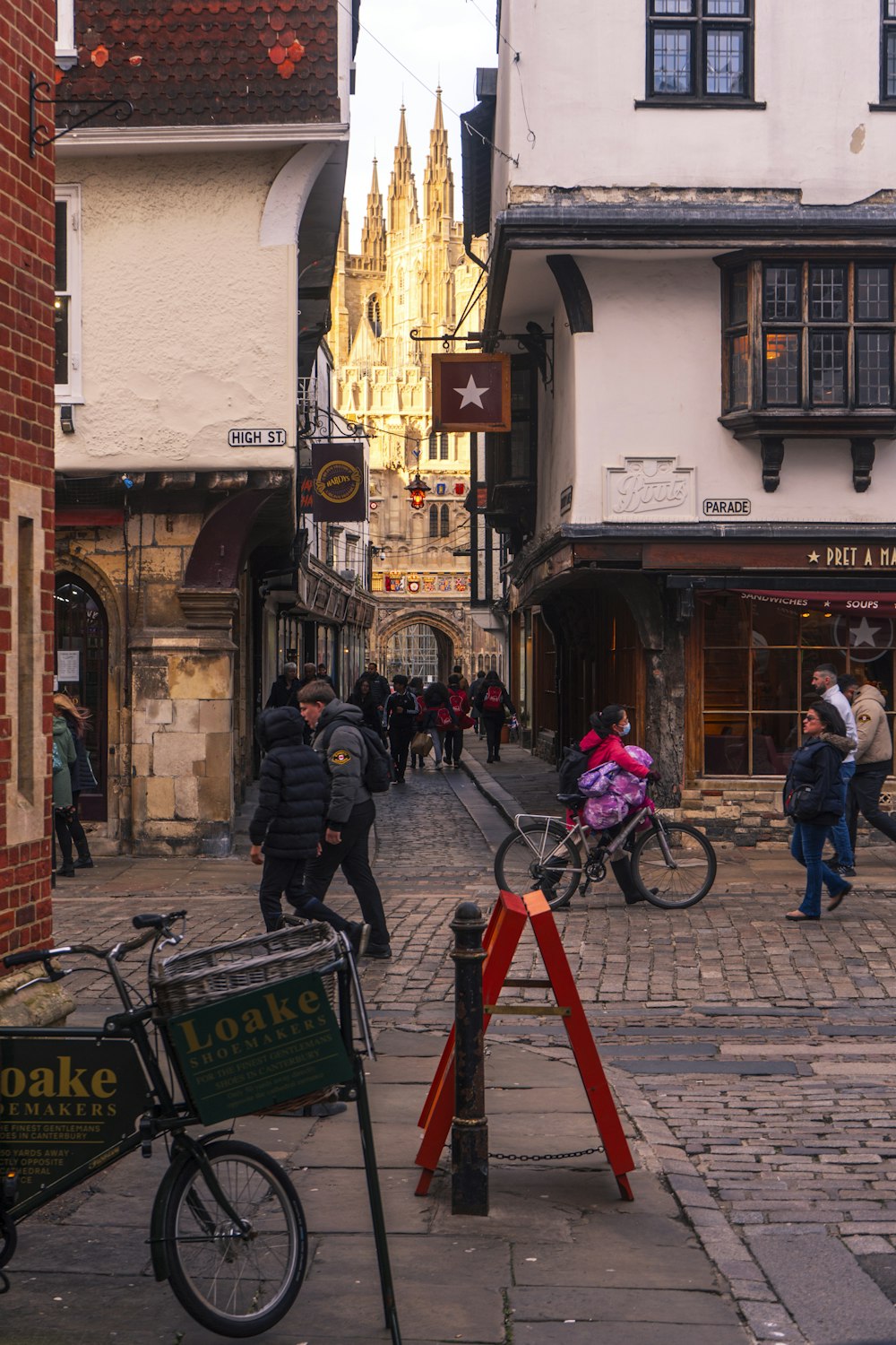 a group of people walking down a street next to tall buildings