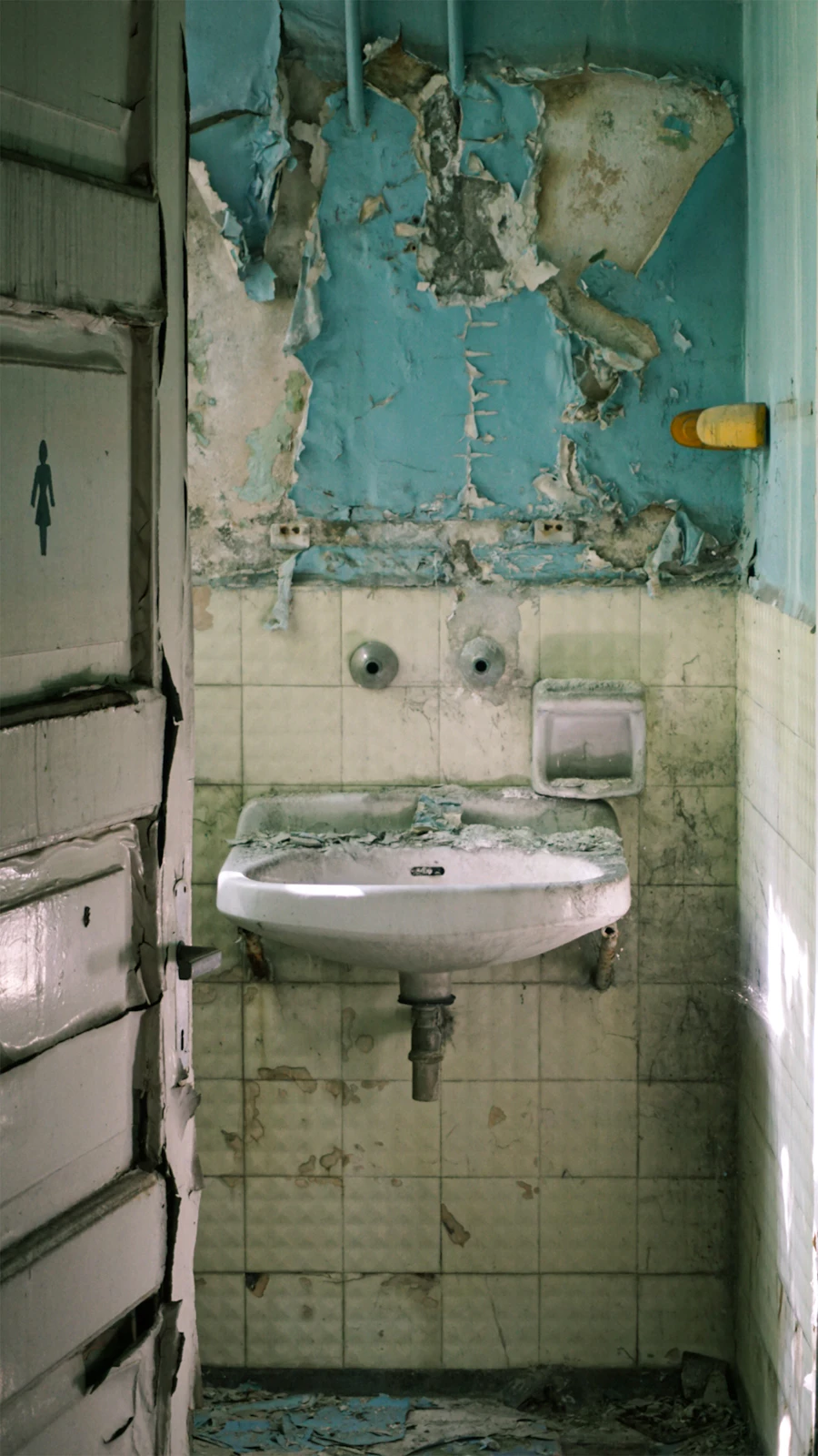 Salle de bain dégradée avant rénovation — vanité et céramique à remplacer