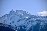 a snow covered mountain with a blue sky in the background