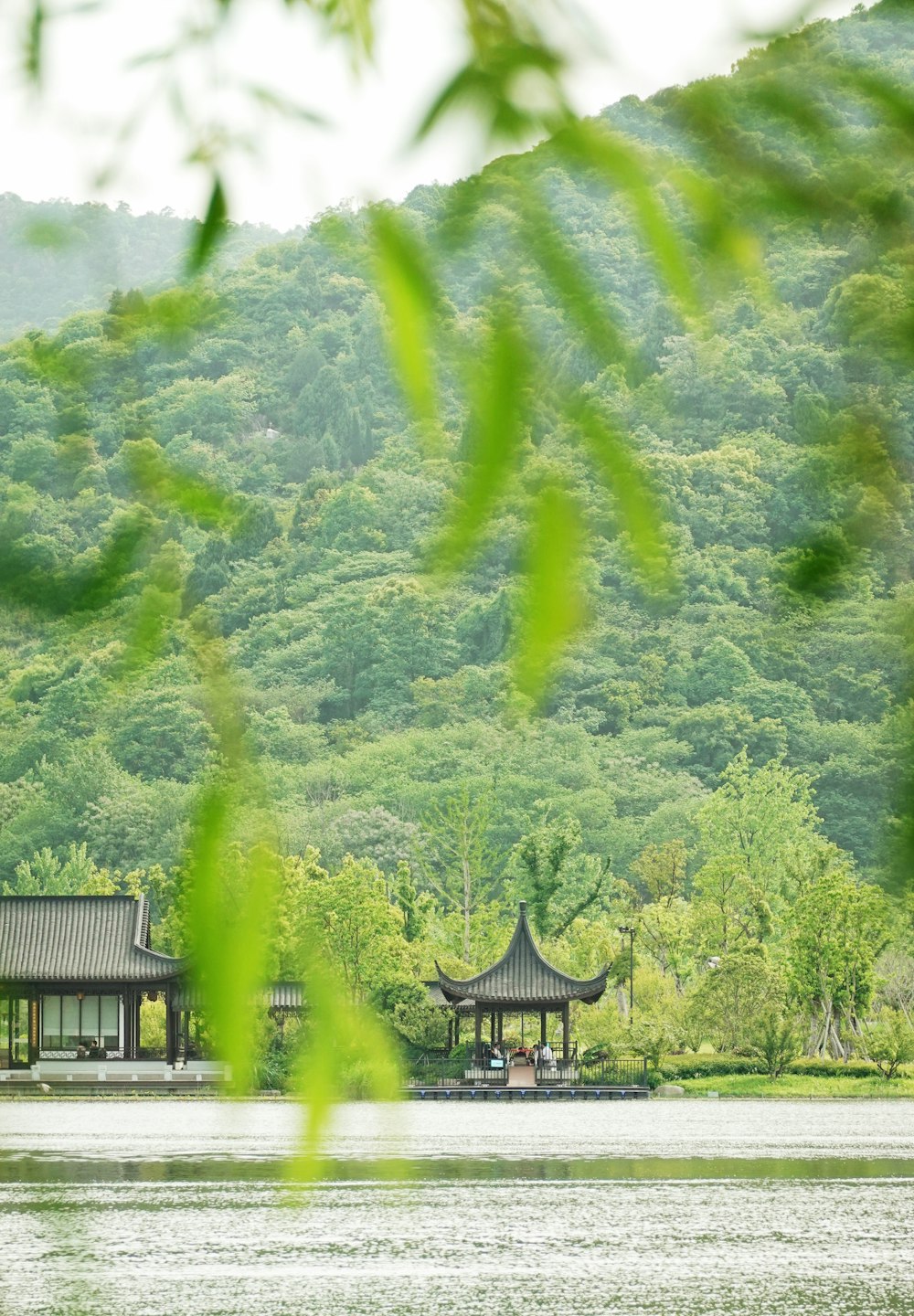 a pagoda on a lake surrounded by trees