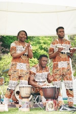 The trio posing together with musical instruments in a tropical setting.