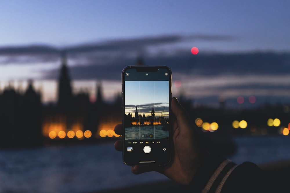 a person taking a picture of a city at night