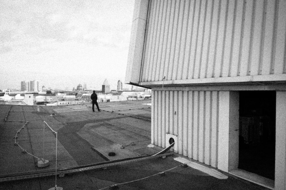 a black and white photo of a person on a roof