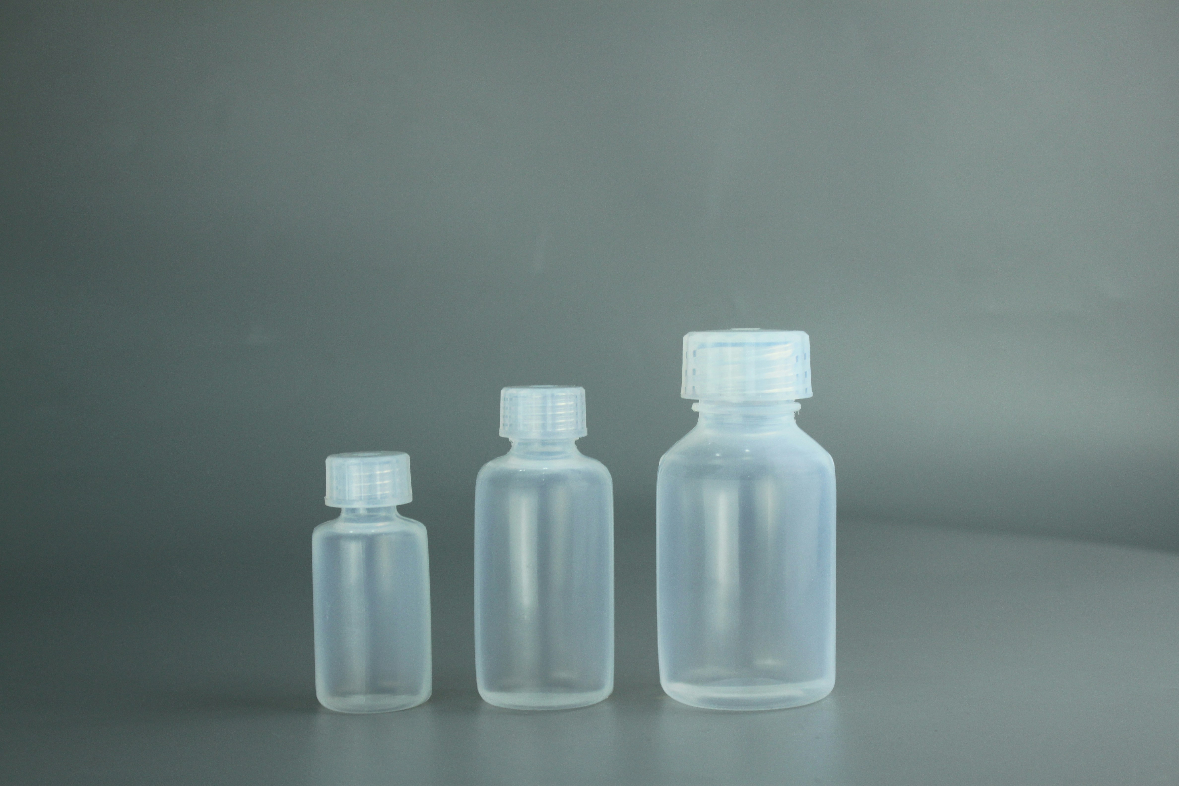 Berbagai jenis botol dan kemasan plastik berwarna-warni di atas permukaan putih