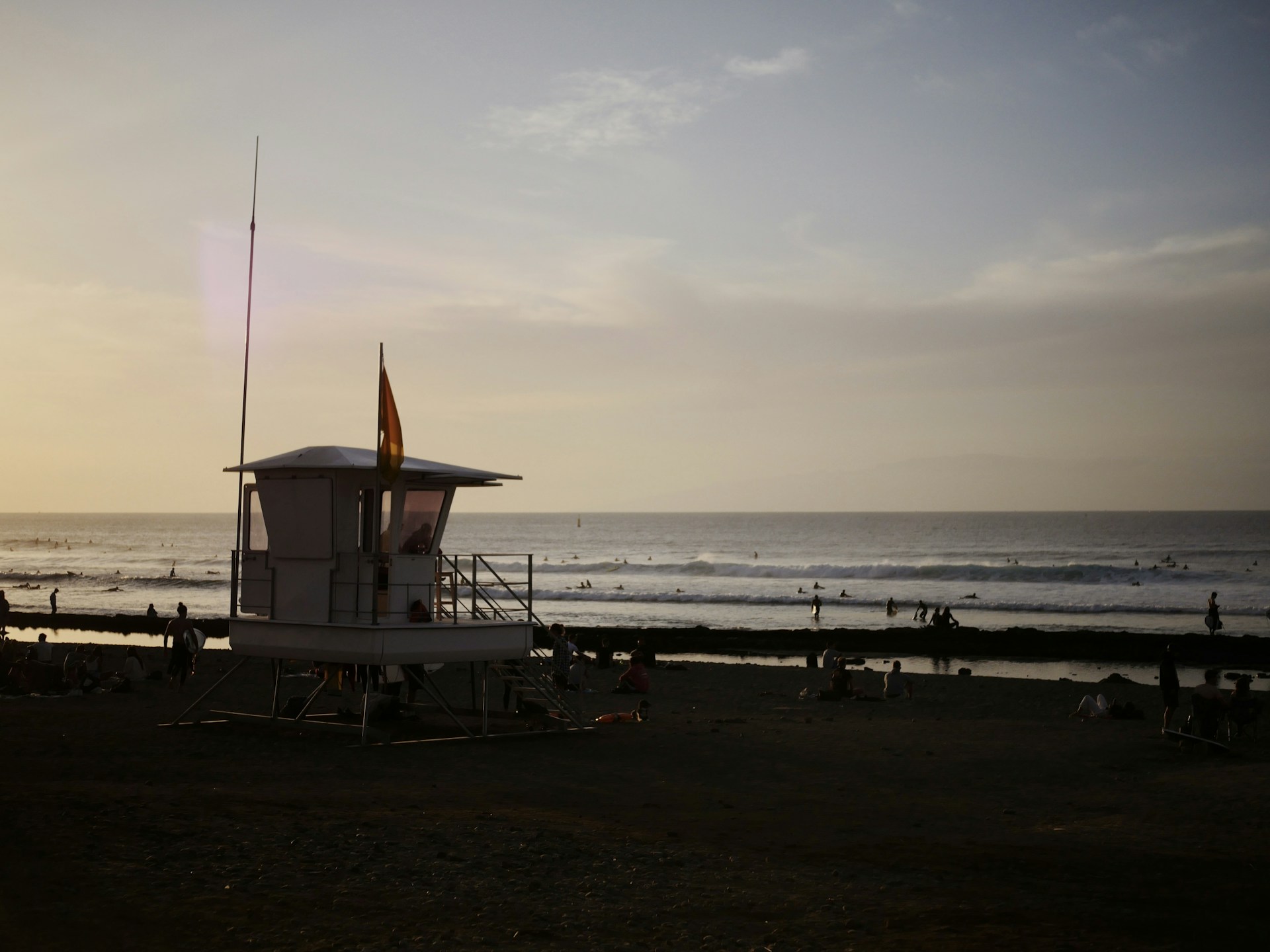 a lifeguard tower on the beach with people in the water
