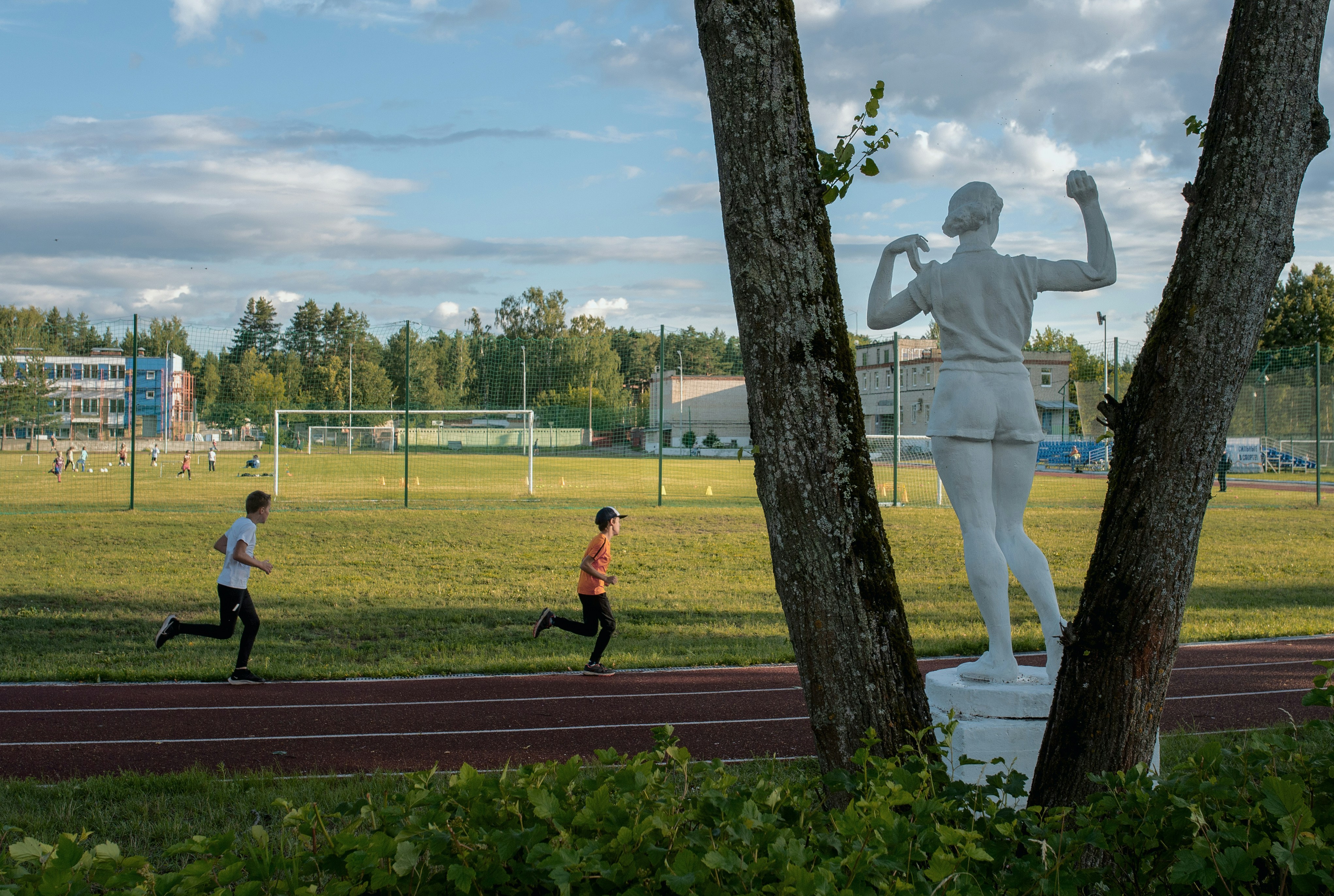 a statue of a man running next to a tree