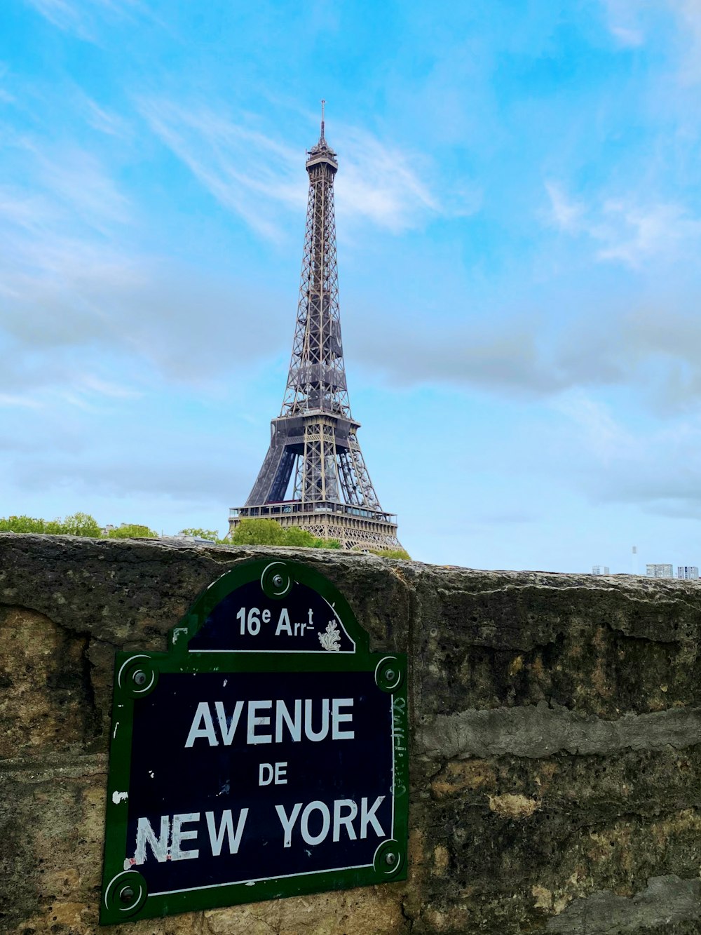 Un panneau qui dit Avenue de New York devant la Tour Eiffel